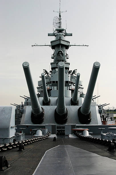 Close up of the battleship USS Alabama Shot of the battleship USS Alabama, docked in Mobile, AL, taken from just in front of the main guns. Focus is on the tip of the middle gun barrel. battleship stock pictures, royalty-free photos & images