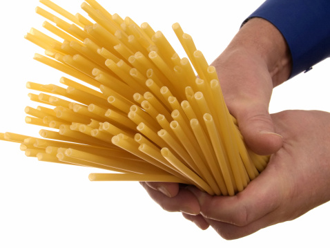 Male hands holding a bunch of uncooked macaroni (isolated on a white background)