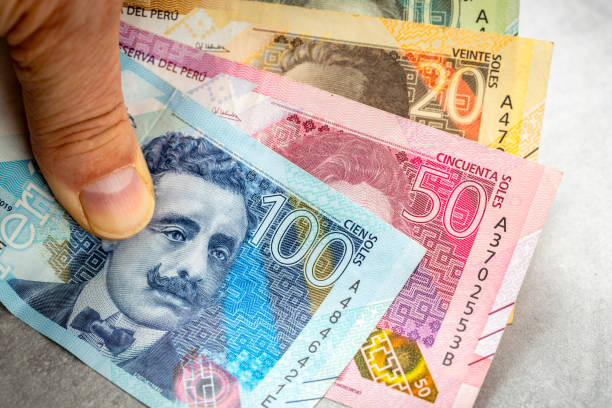 Peru money, Peruvian salt banknotes held in hand, Financial concept, gray background. copy space