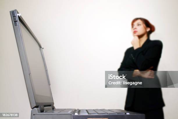 Nachdenklich Frau Stehend In Einen Laptop Stockfoto und mehr Bilder von Arbeiten - Arbeiten, Betrachtung, Drahtlose Technologie