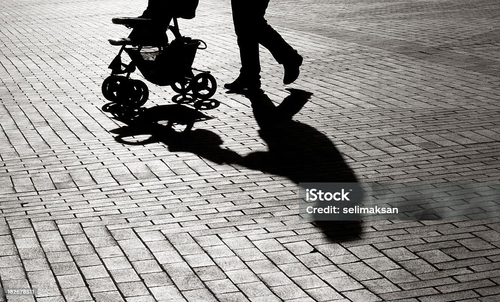 Black And White Shadow Of Baby Carriage On Sidewalk Stones Black And White Shadow Of Baby Stroller On Sidewalk Stones Baby - Human Age Stock Photo