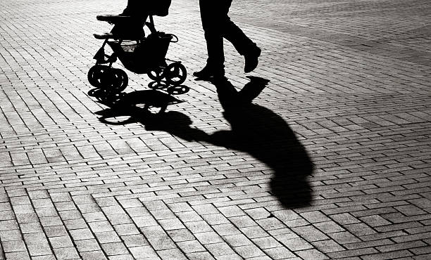 Black And White Shadow Of Baby Carriage On Sidewalk Stones Black And White Shadow Of Baby Stroller On Sidewalk Stones kidnapping photos stock pictures, royalty-free photos & images