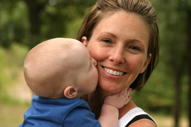 bébé souriant dame embrasser - single mother one parent child kissing photos et images de collection