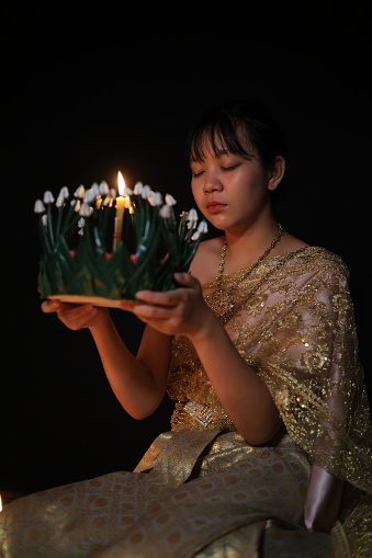 Asian girl with traditional costume hold Krathong to pray respect goodness, Loi Krathong Festival