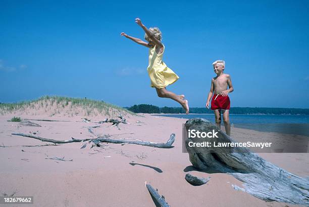 Crianças Jogando E Saltar Em Uma Praia De Areia - Fotografias de stock e mais imagens de Amarelo - Amarelo, Amizade, Ao Ar Livre