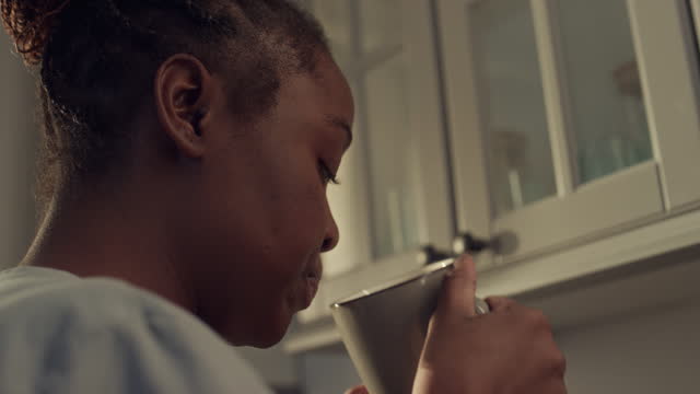 Black Female Nurse Having Coffee and Sandwich before Work