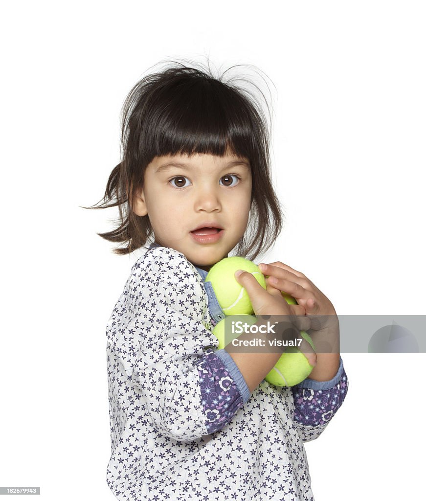 Belle petite fille tenant des balles de tennis - Photo de 12-17 mois libre de droits