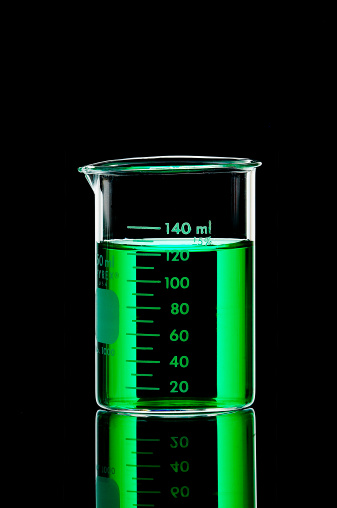 Laboratory beaker filled with green liquid shot on a lowkey background