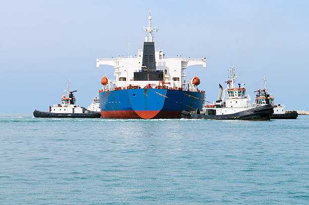 istock Cargo Ship with Tugboats 182680900