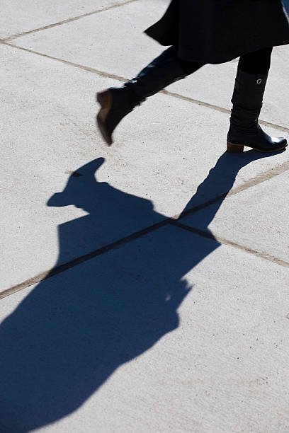 istock silhouette and shadow of a walking woman 182681582
