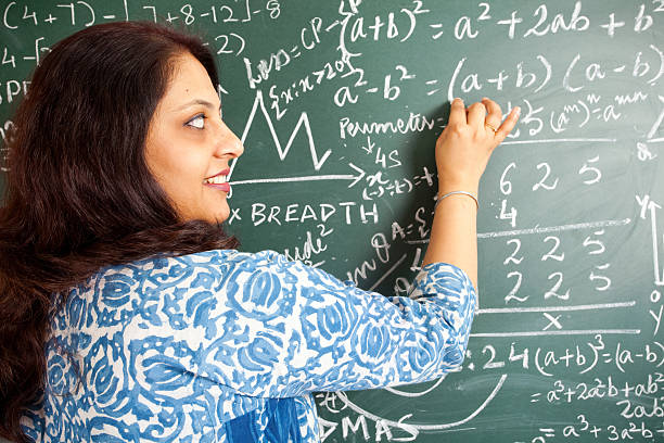 istock Young Cheerful Indian Mathematics Teacher in a Classroom 182682090