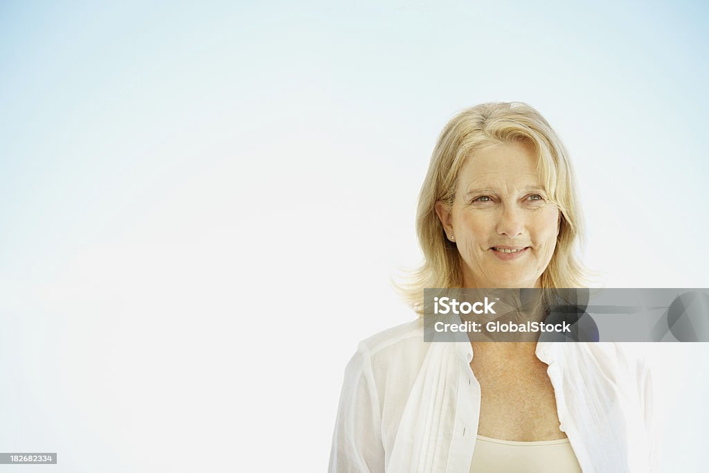 Женщина, стоя против четкие голубое небо - Стоковые фото 50-54 года роялти-фри