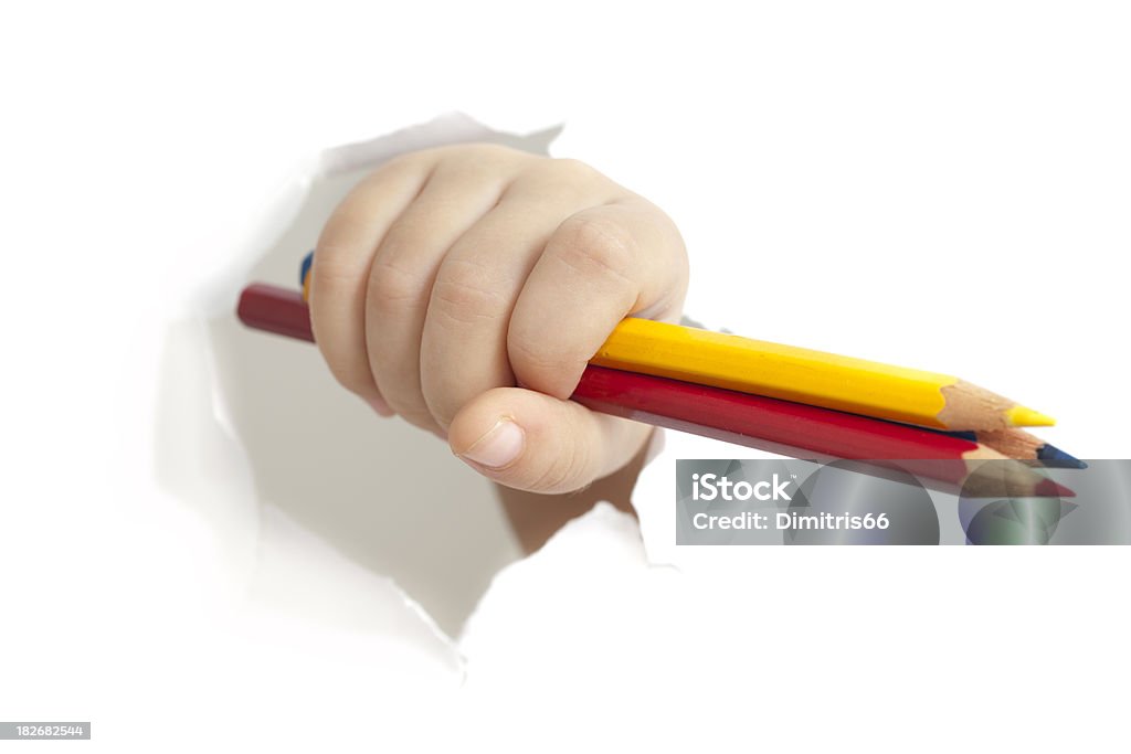 Niño mano con lápices a través del orificio en papel - Foto de stock de Niño libre de derechos