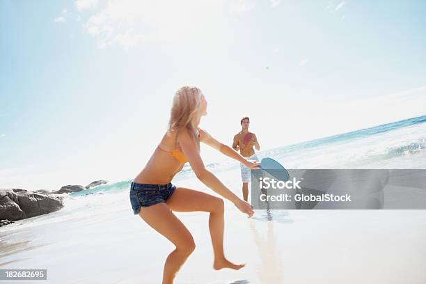 Foto de Casal Desfrutando De Uma Raquete Jogo Na Praia e mais fotos de stock de Praia - Praia, Raquete, 20 Anos