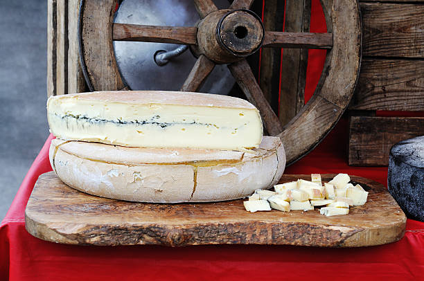 französische morbier käse am marktstand - morbier stock-fotos und bilder