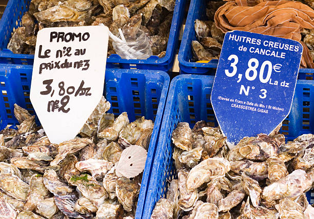 Fresh Oysters Cancale Brittany "From the Oyster Capital of Brittany, Cancale, are baskets of fresh Oysters on a market stall. Special Offer, No 2 Size at the price of No 3 Size, and Huitres Creuses de Cancale - half-shell opened Cancale Oysters from the Bay of Mont Saint Michel. The oysters are Crassostrea Gigas, occasionally called Pacific Oysters or Japanese Oysters. Cancale Oysters were found in the camps of the emperor Julius Caesar and were also taken daily to Versailles for the consumption of Louis XIV. They were even taken by Napoleon on a march to Moscow." cancale photos stock pictures, royalty-free photos & images