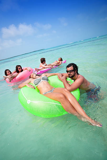 istock Group of young people relaxing with tubes in a beach 182683146