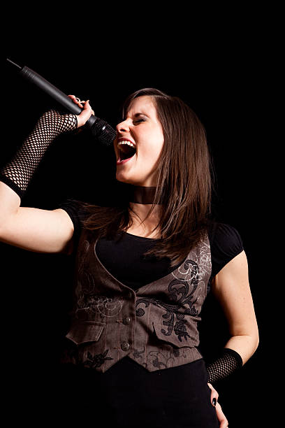 istock Happy Rocker Girl Singing into Microphone on Black Background 182683315