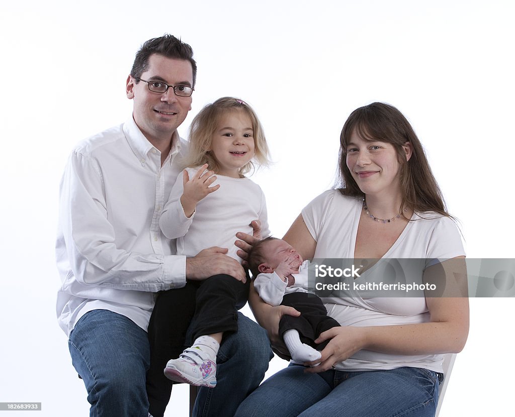 happy family with newborn A group photo of a happy young family wearing white shirts and jeans on a white background in a studio setting. 0-1 Months Stock Photo