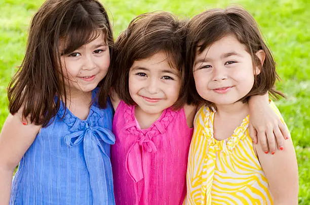 Hispanic Triplet Little Girls wearing Spring Colors