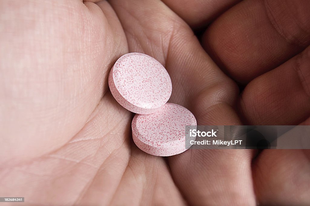 Two Antacid Chewables in Hand - Royalty-free Oesofagale reflux Stockfoto