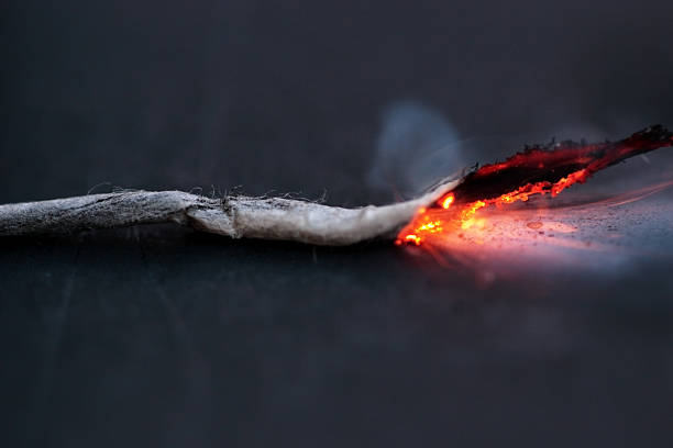 Lit fuse burning on a dark background stock photo