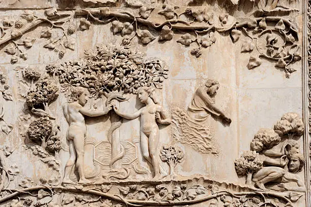 "Italy, Orvieto: detail of the bas-relief on the facade of the Duomo. Adam and Eve tempted by the serpent (XII - XIV c.)"
