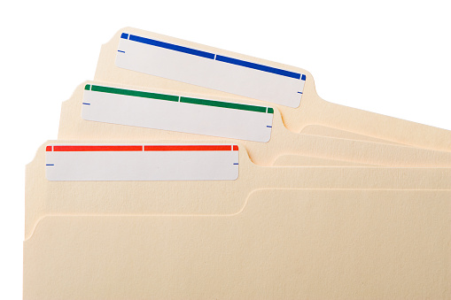 Close up of three manila folders with white labels with color stripes (red, green, blue) tiled against one another, on a white background.