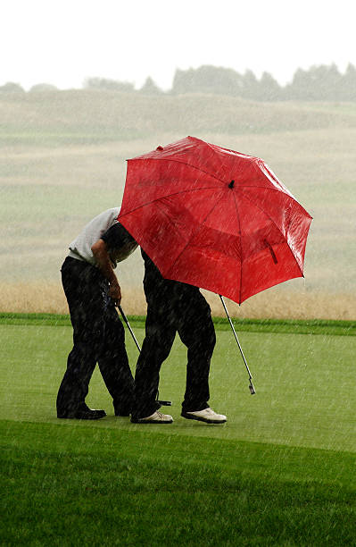 raining golf sonnenschirme - last opportunity emotional stress green stock-fotos und bilder
