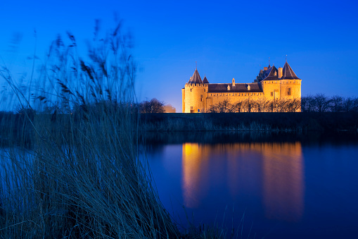 The Dutch 14th century castle of Muiden (Muiderslot). Photographed at dawn when the castle is still illuminated.