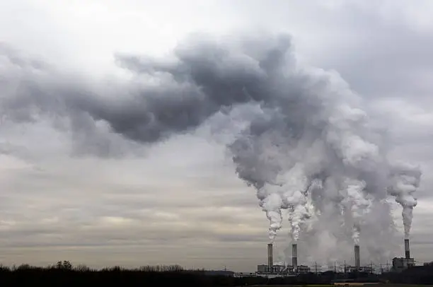 Coal burning power plant with pollution on a cloudy day.