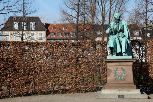 Sculpture of World Famous Danish fairy tale writer and poet Hans Christian Andersen (1805 - 1870) on his favourite spot in the Royal Garden (Kongens Have) Park of Copenhagen ready to read for the children.This (1823 - 1916) statue by August Saabye was errected in 1880.