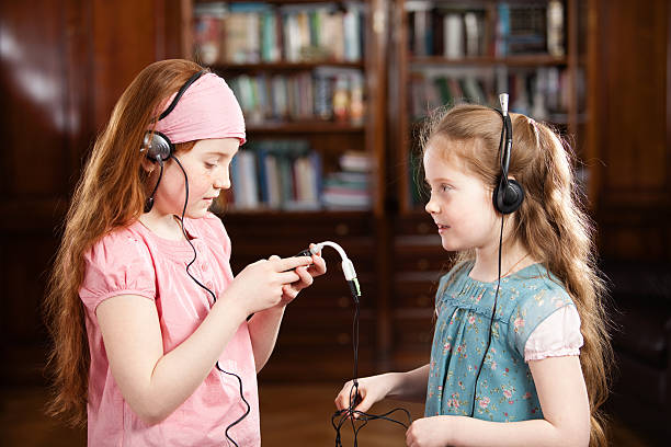 deux filles écouter de la musique et de chant dans - elementary age focus on foreground indoors studio shot photos et images de collection