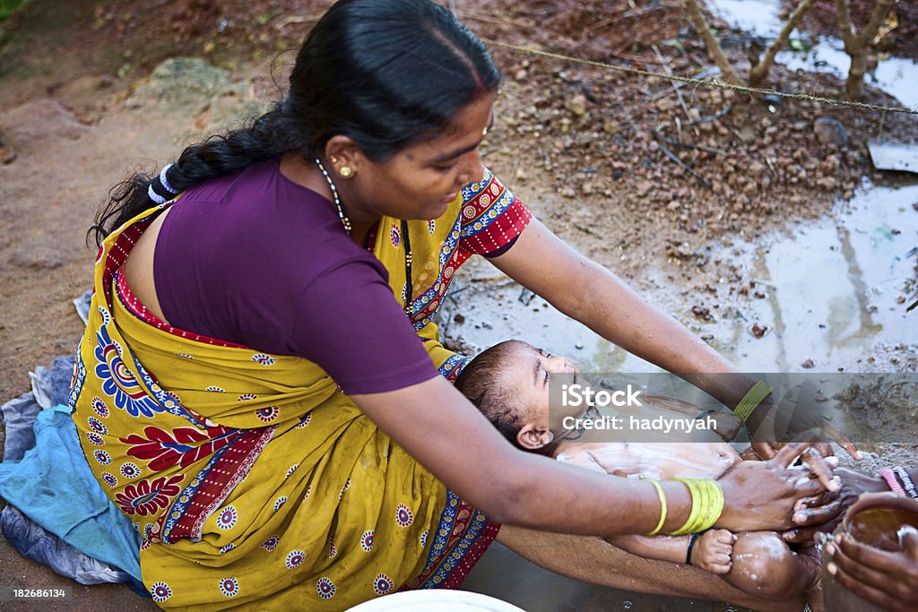 India mujer limpieza su bebé - Foto de stock de Aldea libre de derechos