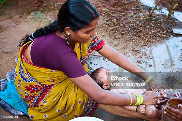 India Mujer Limpieza Su Bebé Foto de stock y más banco de imágenes de Aldea - Aldea, Bebé, Acariciar a un animal