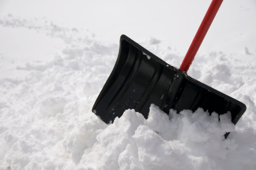 shovel sticking out of a large pile of snow after a big winter storm.See more related images in my Winter Snow Removal lightbox: