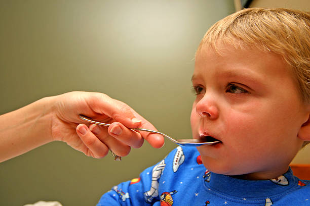 istock Sick Child Having A Dose Of Medicine 182687136