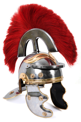 This is a replica of a 1st century Roman Centurion helmet on a white background. The Centurion was a prominent soldier commanded 100 Legionnaires. The red plume was in place to make him appear more ominous and to be seen by their soldiers in combat.