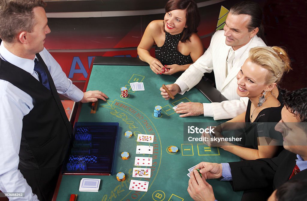 ファッショナブルな人々の Blackjacks テーブルを備えております。 - カジノディーラーのロイヤリティフリーストックフォト