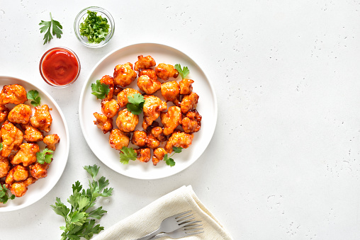 Sweet chili cauliflower wings over light stone background with copy space. Top view, flat lay