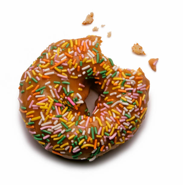 Close-up of sweet donuts on display shelf for sale at a bakery store.