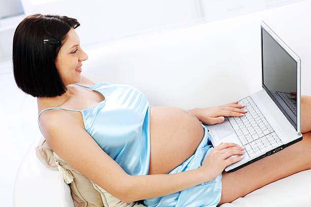 istock Pregnant young woman using a laptop computer on home 182689304