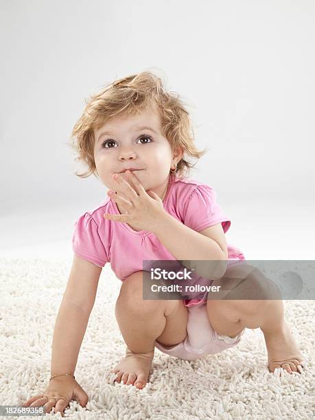 Foto de Bebê Menina Mão Para Os Lábios e mais fotos de stock de Agachando-se - Agachando-se, Bebê, 12-23 meses