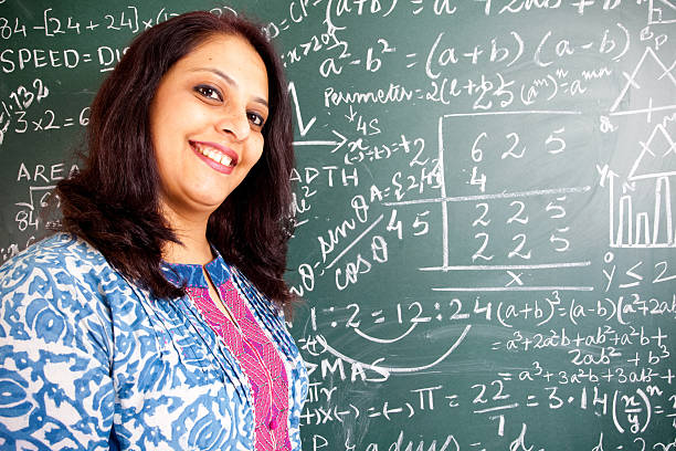 istock Young Cheerful Indian Mathematics Teacher in a Classroom 182689649