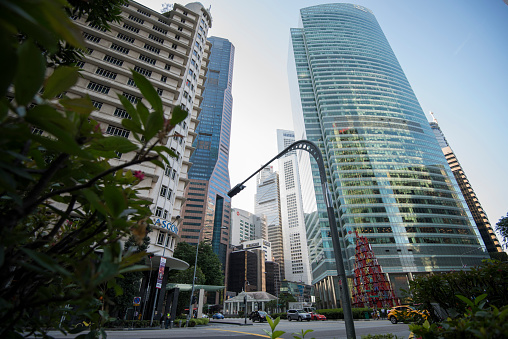 Singapore City, Singapore - September 08, 2019: Low wide-angle view looking up to modern skyscrapers in business district of Singapore City.