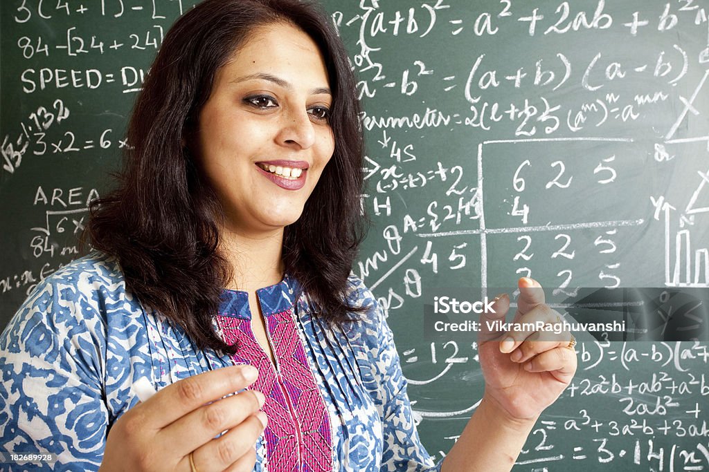 Young Cheerful Indian Mathematics Teacher in a Classroom Young Cheerful Indian Mathematics Teacher in a Classroom interacting with the class 30-39 Years Stock Photo