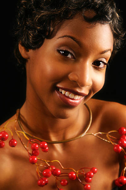 Woman in Cranberry Smiling young woman with a cranberry necklace - shot in studio modeldl stock pictures, royalty-free photos & images