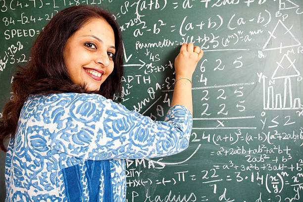 istock Young Cheerful Indian Mathematics Teacher in a Classroom 182690245