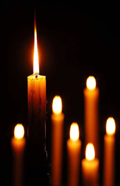 Candle Standing Out "Group of candles burning, sharp focus on the one in the foreground" memorial vigil stock pictures, royalty-free photos & images