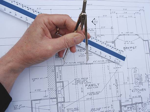 Great room layout Checking the window sizes for the family room. Dividers in hand with ruler in view. autocad house plans stock pictures, royalty-free photos & images